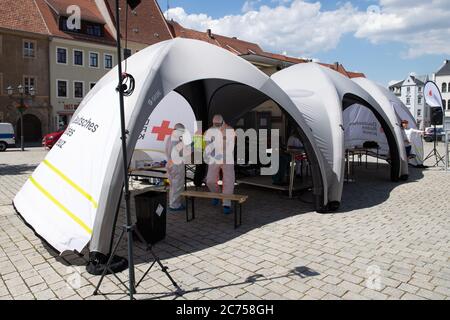 Dippoldiswalde, Deutschland. Juli 2020. Zwei Mitarbeiter des Deutschen Roten Kreuzes (DRK) in Schutzkleidung stehen anlässlich einer Presseveranstaltung in einer mobilen Covid-19-Probenstation. Die Station soll eine standortunabhängige Prüfung von Verdachtsfällen im Freistaat Covid-19 sicherstellen. Quelle: Sebastian Kahnert/dpa-Zentralbild/dpa/Alamy Live News Stockfoto