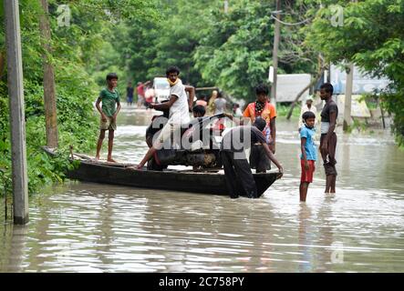 Kamrup, Assam, Indien. Juli 2020. Dorfbewohner nutzen ein Landboot, um sich in einem Dorf im Kamrup-Distrikt Assam durch Monsunregen überfluteten Ort zu bewegen. Kredit: David Talukdar/ZUMA Wire/Alamy Live Nachrichten Stockfoto