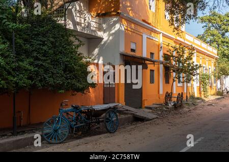 Pondicherry. Indien - Februar 2020: Alte französische Ära Häuser in hellen gelb-orange Farben auf einer ruhigen Straße in der Altstadt gemalt. Stockfoto