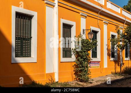 Pondicherry. Indien - Februar 2020: Alte französische Ära Häuser in hellen gelb-orange Farben auf einer ruhigen Straße in der Altstadt gemalt. Stockfoto