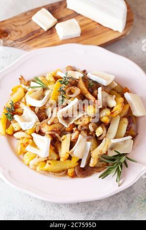 Pommes Frites Kartoffel mit Zwiebel und Camembert-Käse Stockfoto