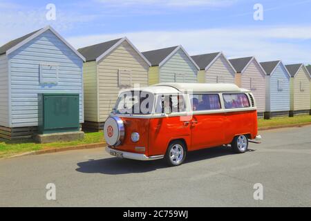 Klassischer Volkswagen Wohnmobil mit Strandhütten im Hintergrund in der Nähe von Broadsands Beach, Devon Stockfoto