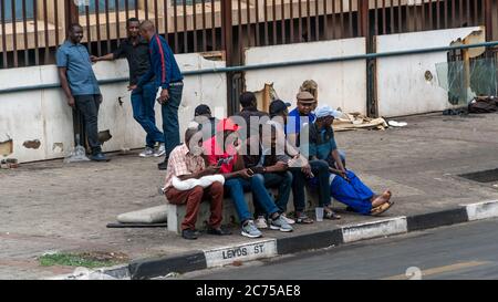 Johannesburg, Südafrika - Oktober 2019: Gruppe von Menschen in Johannesburg sitzen zusammen an der Straße Stockfoto