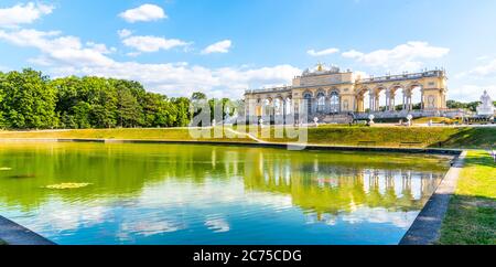 WIEN, ÖSTERREICH - 23. JULI 2019: Die Gloriette im Schlosspark Schönbrunn, Wien, Österreich. Vorderansicht und Wasserspiegelung. Stockfoto