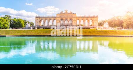 WIEN, ÖSTERREICH - 23. JULI 2019: Die Gloriette im Schlosspark Schönbrunn, Wien, Österreich. Vorderansicht und Wasserspiegelung. Stockfoto