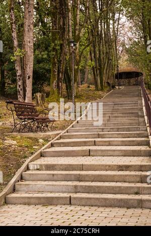 Stadtbild. In einem alten Park führt eine geflieste Steintreppe nach oben. Sotschi, Russland Stockfoto