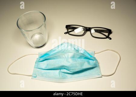OP-Maske auf der Theke, Gläser und leeres Glas, Draufsicht Stockfoto