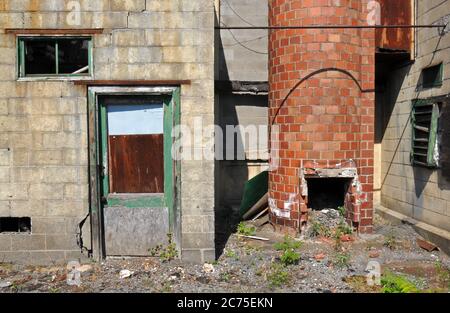 Eine alte Tür und ein Ziegelrauchkestack im ehemaligen Pierce-Arrow-Automobilfabrik-Komplex in Buffalo, New York, entworfen vom Architekten Albert Kahn. Stockfoto