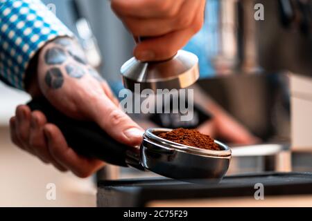 Nahaufnahme Des Barista Hands Holding Portafilter Mit Gemahlenem Kaffee. Kaffeevorbereitung Zu Hause. Guter Kaffee Ohne Zu Hause Zu Verlassen Stockfoto