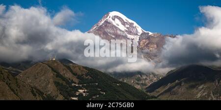 Mt. Kazbegi umgeben von Wolken, in einem Morgen des August 2019 Stockfoto