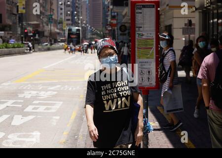 Hongkong, CHINA. Juli 2020. Maskierte Frau geht an einer Bushaltestelle im geschäftigen Geschäftsviertel an der Hauptstraße an der Nathan Road vorbei. Die dritte Welle des Coronavirus-Angriffs ist in Hongkong zurückgekehrt und bringt neue Angst unter den Bürgern. Die Stadt wird erneut durch die Persistenz des Coronavirus alarmiert, das durch den Ausbruch der chinesischen Lungenentzündung eingeführt wurde.die Lungenentzündung entstand in der Stadt Wuhan, Provinz HUBEI auf dem chinesischen Festland.Juli-14, 2020 Hongkong.ZUMA/Liau Chung-ren Credit: Liau Chung-ren/ZUMA Wire/Alamy Live News Stockfoto