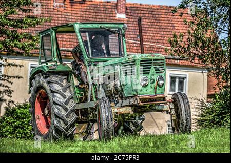 Ein deutscher Oldtimer-Traktor steht auf einer grünen Wiese Stockfoto