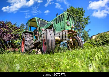 Ein deutscher Oldtimer-Traktor steht auf einer grünen Wiese Stockfoto