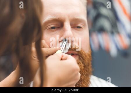 Entfernen von Haaren aus der Nase mit Wachs in Friseurladen, männliche Schönheit und Pflege-Konzept Stockfoto