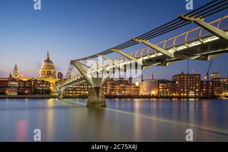 Die kultige Aussicht auf die Themse der Millennium Bridge und St Pauls Cathedral, beleuchtet auf einer klaren Sommer Abend während der blauen Stunde. Stockfoto