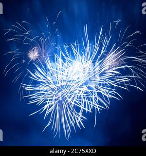 Blaues buntes Feuerwerk in Herzform auf dem schwarzen Himmel Hintergrund. Feiertagsfeier. Stockfoto