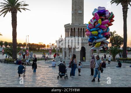 IZMIR, TÜRKEI,12. JULI 2020: Menschen, die am Ende des Sommertages Zeit am Strand von Konak und rund um die Uhr am Turm verbringen. Stockfoto