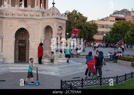 IZMIR, TÜRKEI,12. JULI 2020: Menschen, die am Ende des Sommertages Zeit am Strand von Konak und rund um die Uhr am Turm verbringen. Stockfoto