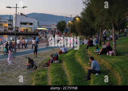 IZMIR, TÜRKEI,12. JULI 2020: Menschen, die am Ende des Sommertages Zeit am Strand von Konak und rund um die Uhr am Turm verbringen. Stockfoto