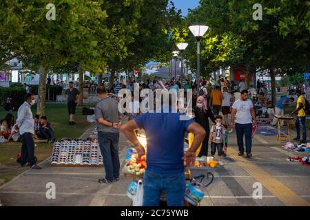 IZMIR, TÜRKEI,12. JULI 2020: Menschen, die am Ende des Sommertages Zeit am Strand von Konak und rund um die Uhr am Turm verbringen. Stockfoto