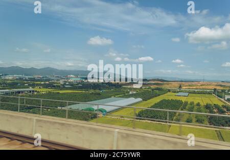 Blick auf Gewächshäuser und landwirtschaftliche Felder mit Pflanzen und Obstgärten in der ländlichen Gegend von Südkorea Stockfoto