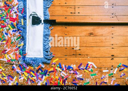 Ein Pushbroom, der Konfetti nach einer Party oder Feier aufputzt. Stockfoto