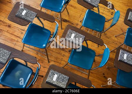 Eine Gruppe von Schulschreibtischen mit Notizbüchern. Stockfoto