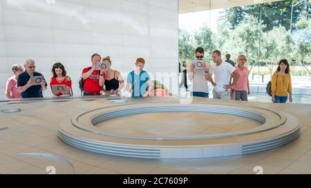 Cupertino, CA, USA - August 2019: Apple Store Cupertino mit Menschen, die Infinite Loop Apple Headquarters durch virtuelle Realität mit iPad Tab Stockfoto