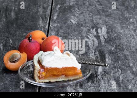 Leckere Meringuekuchen mit frischer Aprikose auf Holztisch Stockfoto