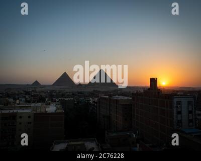 Blick auf die Pyramiden bei Sonnenuntergang vom Dach von gizeh mit Skyline Stockfoto