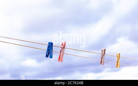Bunte Wäscheklammern an einem Seil gegen den Himmel Stockfoto