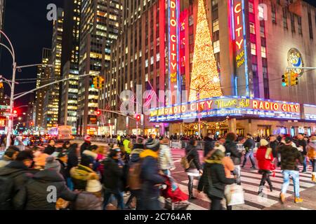 Eine Menschenmenge überquert die 6th Avenue vor der Radio City Music Hall Stockfoto