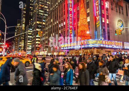 Eine Menschenmenge überquert die 6th Avenue vor der Radio City Music Hall Stockfoto