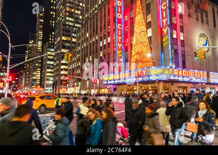 Eine Menschenmenge überquert die 6th Avenue vor der Radio City Music Hall Stockfoto