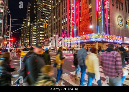 Eine Menschenmenge überquert die 6th Avenue vor der Radio City Music Hall Stockfoto