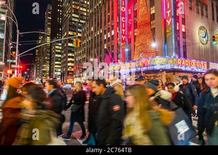 Eine Menschenmenge überquert die 6th Avenue vor der Radio City Music Hall Stockfoto