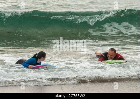 Owenahincha, West Cork, Irland. Juli 2020. Vater und Tochter Barry und Grace Sorensen aus Tramore, County Waterford, haben Spaß beim Bodyboarden am Red Strand Beach, West Cork, trotz des kalten Wetters. Quelle: AG News/Alamy Live News Stockfoto