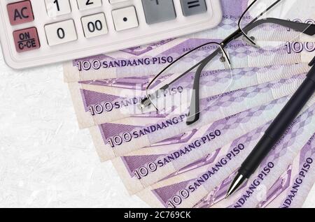 100 Philippine piso Bills Ventilator und Rechner mit Brille und Stift. Geschäftskredit oder Steuerzahlung Saisonkonzept. Finanzplanung Stockfoto