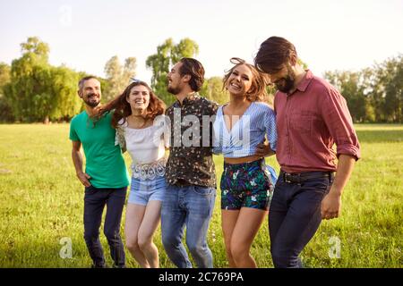 Millennial Freunde genießen ihre Zeit im Freien. Fröhliche Mädchen und Jungs verbringen Sommertag auf dem Land Stockfoto