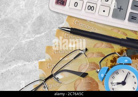 100 kanadische Dollar Rechnungen und Rechner mit Brille und Stift. Geschäftskredit oder Steuerzahlung Saisonkonzept. Finanzplanung und Zeit, Steuern zu zahlen Stockfoto