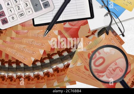 50 kanadische Dollar Rechnungen und Rechner mit Brille und Stift. Tax Payment Saison Konzept oder Investment-Lösungen. Suche nach einem Job mit hohem Gehalt EA Stockfoto