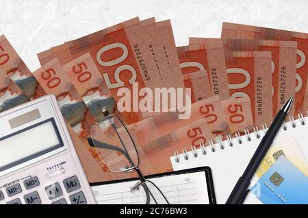 50 kanadische Dollar Rechnungen und Rechner mit Brille und Stift. Tax Payment Saison Konzept oder Investment-Lösungen. Finanzplanung oder Buchhalter pa Stockfoto