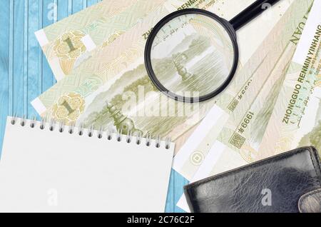 1 chinesische Yuan-Scheine und Lupe mit schwarzem Geldbeutel und Notizblock. Konzept von gefälschtem Geld. Suchen Sie nach Unterschieden in Details zu Geldrechnungen Stockfoto