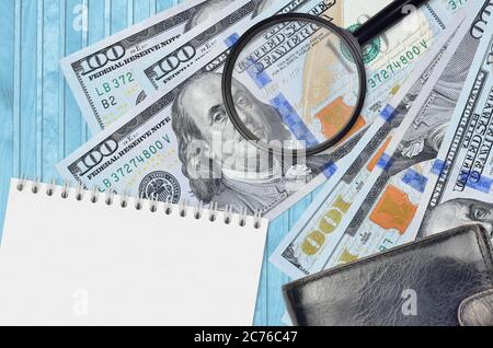 100 US-Dollar Scheine und Lupe mit schwarzem Geldbeutel und Notizblock. Konzept von gefälschtem Geld. Suchen Sie nach Unterschieden in Details zu Geldrechnungen Stockfoto