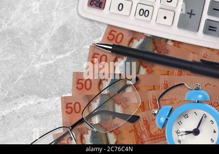 50 kanadische Dollar Rechnungen und Rechner mit Brille und Stift. Geschäftskredit oder Steuerzahlung Saisonkonzept. Finanzplanung und Zeit, Steuern zu zahlen Stockfoto