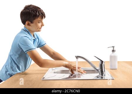 Profilaufnahme eines Jungen, der sich in einem Waschbecken auf weißem Hintergrund die Hände wascht Stockfoto