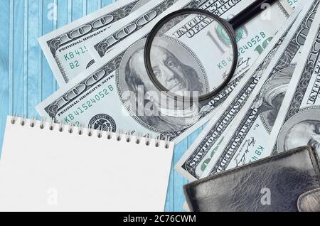 100 US-Dollar Scheine und Lupe mit schwarzem Geldbeutel und Notizblock. Konzept von gefälschtem Geld. Suchen Sie nach Unterschieden in Details zu Geldrechnungen Stockfoto