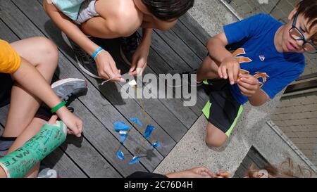 Tageslager, Brooklyn, New York City. Kinder bauen Türme aus Spaghetti, um mehr über Teamwork und Balance zu erfahren. Stockfoto