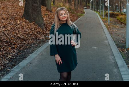 Ein schönes Mädchen geht entlang der Gasse im Herbstpark. Stockfoto