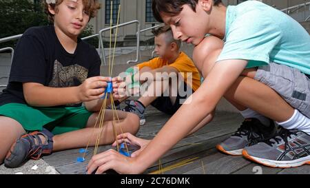 Tageslager, Brooklyn, New York City. Kinder bauen Türme aus Spaghetti, um mehr über Teamwork und Balance zu erfahren. Model-Release. Stockfoto